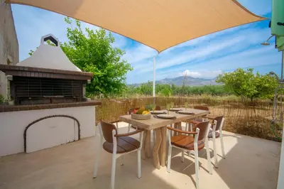 a table and chairs with an umbrella on a patio at NiMa Maison in Kissamos