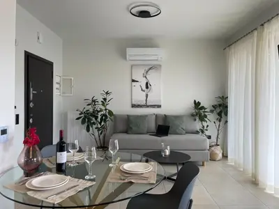 a living room with a glass table and a couch at Mossa City Apartments - 2 km from Old Town - Private parking in Chania Town