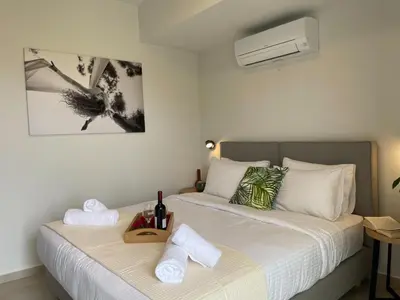a bedroom with two beds with towels and a air conditioner at Mossa City Apartments - 2 km from Old Town - Private parking in Chania Town