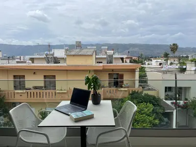 a laptop computer sitting on a table on a balcony at Mossa City Apartments - 2 km from Old Town - Private parking in Chania Town