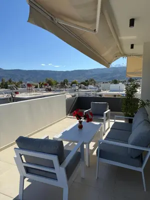 a patio with a table and chairs on a roof at Mossa City Apartments - 2 km from Old Town - Private parking in Chania Town