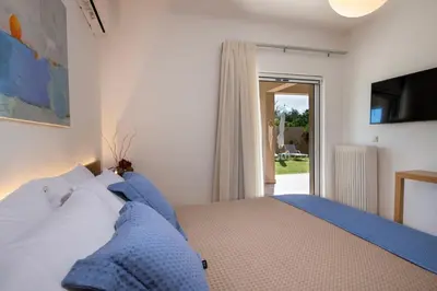 a bedroom with a bed with blue pillows at Meraki Cretan Hospitality in Maleme