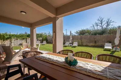 a wooden table and chairs on a patio at Meraki Cretan Hospitality in Maleme