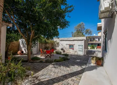 a courtyard with a tree and a house at Meraki Cretan Hospitality in Maleme