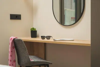 a mirror sitting on a desk with a chair at Limani elegant apartments in Souda