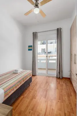 a bedroom with a bed and a sliding glass door at 3 bedroom apt in Nea Chora 400 meters walk to the beach in Chania Town