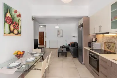 a kitchen and a living room with a dining room table at 3 bedroom apt in Nea Chora 400 meters walk to the beach in Chania Town