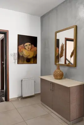 a mirror and a vase on a counter in a room at 3 bedroom apt in Nea Chora 400 meters walk to the beach in Chania Town