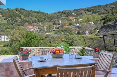 a table with a bowl of fruit on a balcony at Stone house for relaxation in Elos in Kissamos