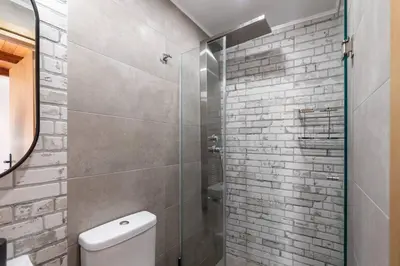 a bathroom with a toilet and a glass shower at Casa Nicola's in Chania Town