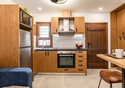 a kitchen with wooden cabinets and a stainless steel refrigerator at Casa Nicola's in Chania Town