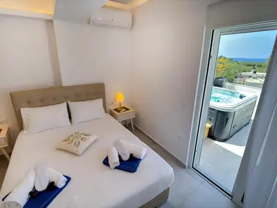 a bedroom with a bed with towels on it at Luxury Dream with Private Jacuzzi in Kaloudhianá