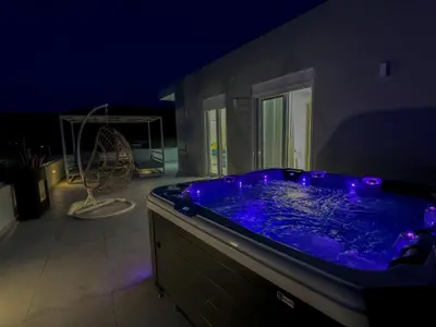 a large blue tub with purple lights in a room at Luxury Dream with Private Jacuzzi in Kaloudhianá