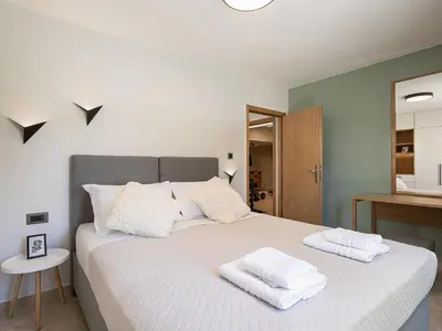 a bedroom with a bed with two towels on it at Elysian Sea-View Chania in Stérnai