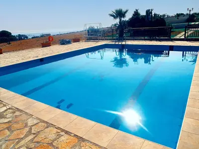 a large swimming pool with blue water at Dreamy South Sea View Apartments with Pool in Frangokastello