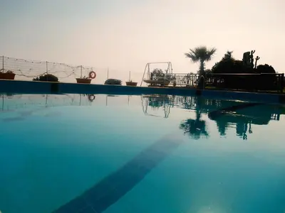 a large swimming pool with a roller coaster in the background at Dreamy South Sea View Apartments with Pool in Frangokastello