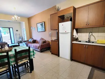 a kitchen with a white refrigerator and a couch at Dreamy South Sea View Apartments with Pool in Frangokastello