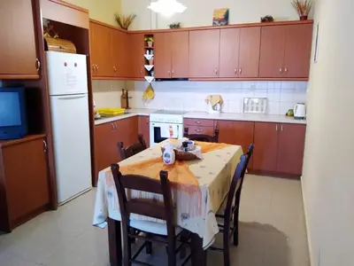 a kitchen with a table with chairs and a refrigerator at Dreamy South Sea View Apartments with Pool in Frangokastello