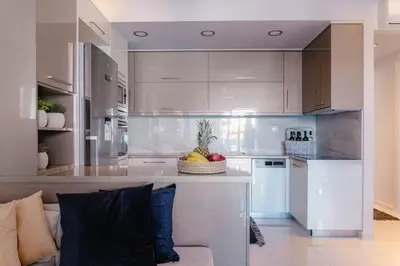 a kitchen with white cabinets and a couch in a room at G&M Luxury Residence with pool in Chania Town