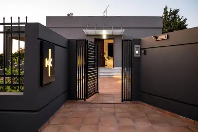 a walkway leading to a house with a black fence at Chania lux villa with Heated pool in Chania Town