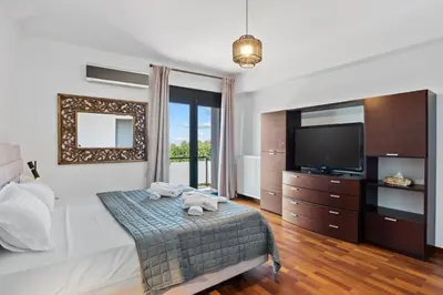 a hotel room with a bed and a television at Chania lux villa with Heated pool in Chania Town