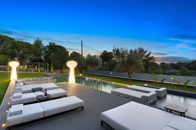 a deck with white lounge chairs and a pool at Chania lux villa with Heated pool in Chania Town