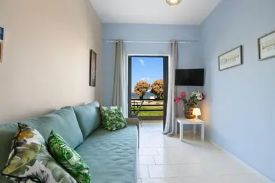 a living room with a blue couch and a window at Sun Beach Apartments in Chania 8 &10& 13 in Chania Town