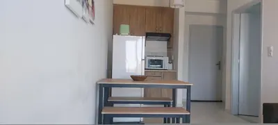 a small kitchen with a table and a refrigerator at Sun Beach Apartments in Chania 8 &10& 13 in Chania Town