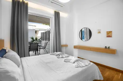 a bedroom with a white bed and a mirror at Apartment Arancione in Chania Town