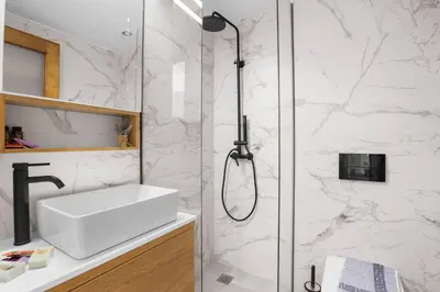 a bathroom with a shower with a white sink at Apartment Arancione in Chania Town
