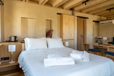 a bedroom with a large white bed with two towels on it at Kallergon Luxury Suites in Chania Town