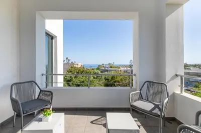 a balcony with two chairs and a view of the ocean at Crystal Waves lux villa-Homeleader in Chania Town