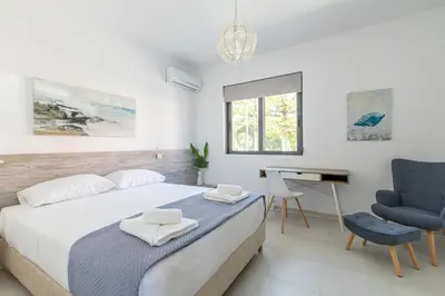 a bedroom with a bed and a desk and a chair at Crystal Waves lux villa-Homeleader in Chania Town
