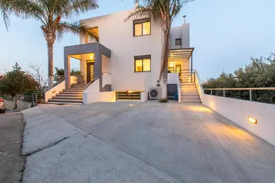 a house with palm trees in front of it at Crystal Waves lux villa-Homeleader in Chania Town
