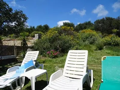 three white lawn chairs sitting in the grass at Tsikalaria Traditional Stone House in Tsikalariá
