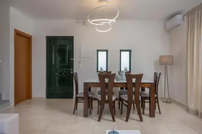 a dining room with a wooden table and chairs at Villa Georgia Heated Pool & Jet-Tub in Kolymvari