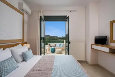 a bedroom with a bed and a view of a living room at Villa Georgia Heated Pool & Jet-Tub in Kolymvari