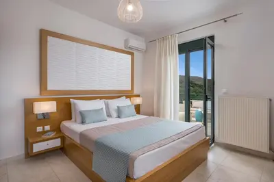 a bedroom with a bed and a large window at Villa Georgia Heated Pool & Jet-Tub in Kolymvari