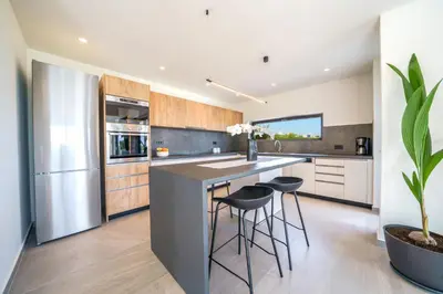 a kitchen with a large island with stools at ISKIOS Premium in Agia Marina Nea Kydonias