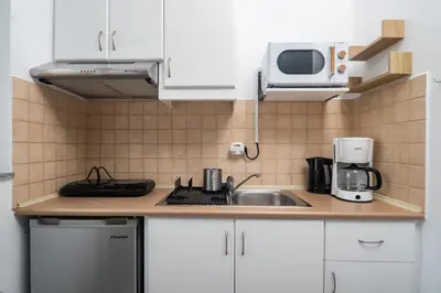 a kitchen with white cabinets and a sink and a microwave at ''Meraviglia'' casa ''Nefeli'' in Chania Town