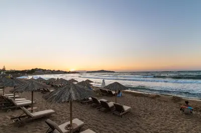 a beach with chairs and umbrellas and the ocean at ''Meraviglia'' casa ''Nefeli'' in Chania Town