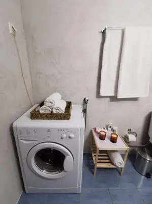a washing machine in a bathroom with a table at Comfy APT in Chania City Center in Chania Town