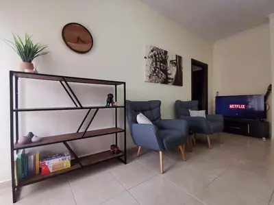 a living room with two chairs and a tv at Comfy APT in Chania City Center in Chania Town