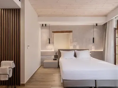 a bedroom with a white bed and a chair at Casa Dorini in Chania Town