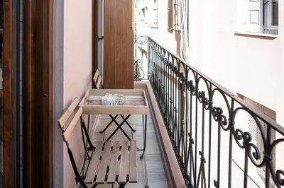 a wooden table on a balcony with a bench at Casa Dorini in Chania Town
