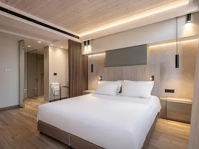 a bedroom with a large white bed and a bathroom at Casa Dorini in Chania Town