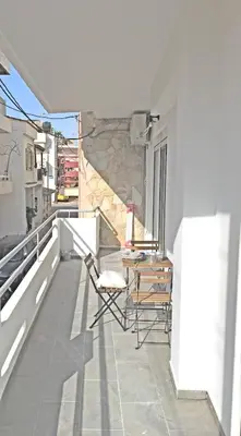 a balcony with chairs and a table on a building at Pegasus Amazing Flat, 1,5min Walk To The Beach in Chania Town