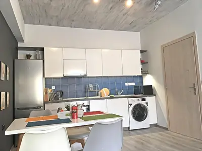 a kitchen with white cabinets and a washer and dryer at Pegasus Amazing Flat, 1,5min Walk To The Beach in Chania Town