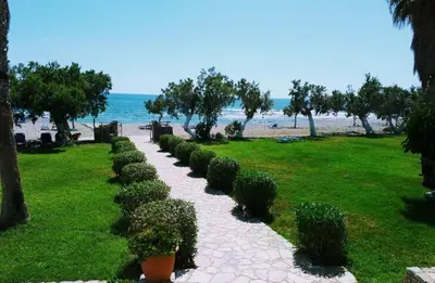 a walkway next to a beach with bushes at Studios Stavris in Frangokastello