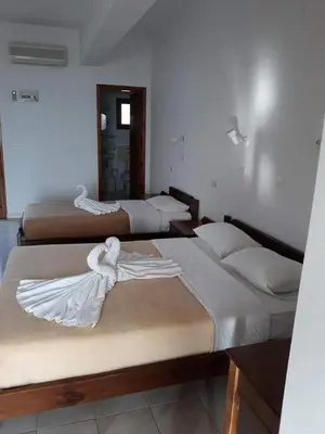 a group of three beds in a room at Studios Stavris in Frangokastello